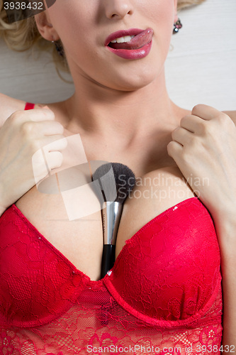 Image of female breast with a brush for powder