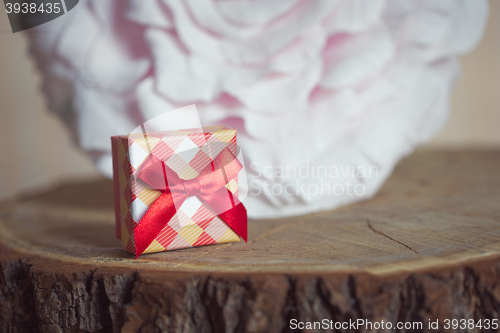 Image of Gift box with red bow on wood background