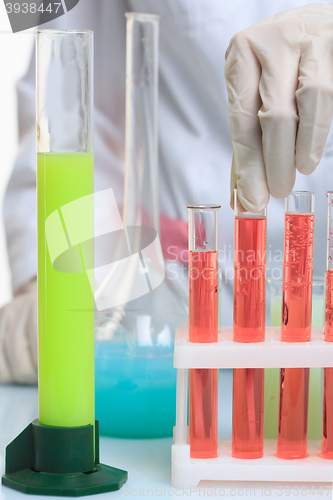 Image of hands holding test tubes with chemical elements. 