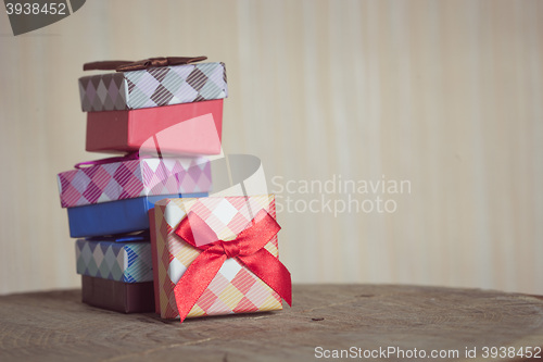 Image of Gift box with red bow on wood background