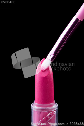 Image of Tube of lipstick with a brush make-up on black 