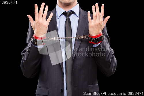 Image of man in a business suit with leather bound. handcuffs. sex Toys