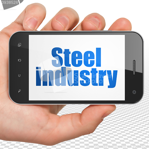 Image of Industry concept: Hand Holding Smartphone with Steel Industry on display