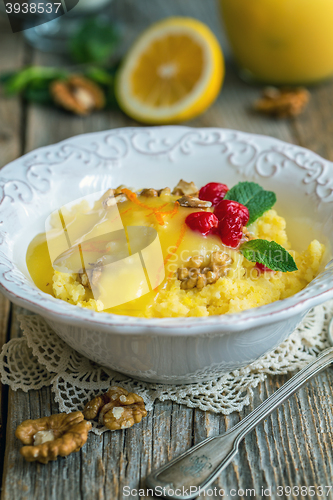 Image of Tasty millet porridge with lemon cream and nuts for breakfast.