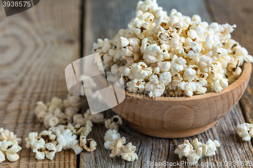 Image of Popcorn in wooden bowl close up.