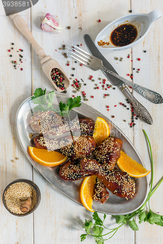 Image of Fried chicken drumsticks in honey glaze with sesame seeds.