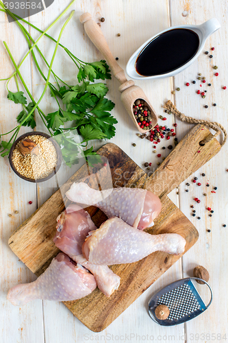 Image of Raw chicken drumsticks and ingredients for hot sauce.