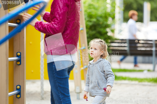 Image of Mother and daughter playing on the playground outdoors