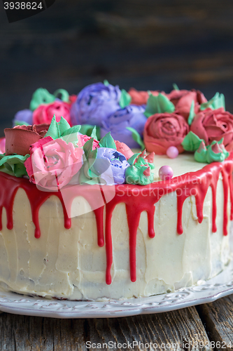 Image of Cake with flowers and red chocolate icing.