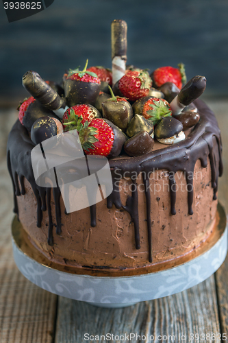 Image of Cake decorated with strawberries, chocolates and wafer rolls.