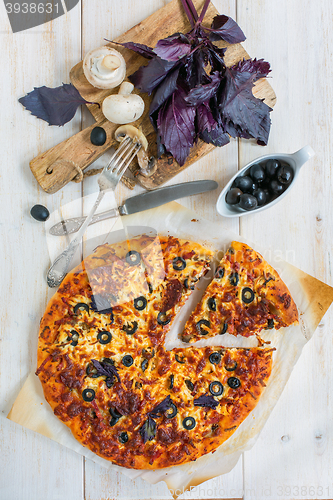 Image of Large pizza with salami, olives and cheese.