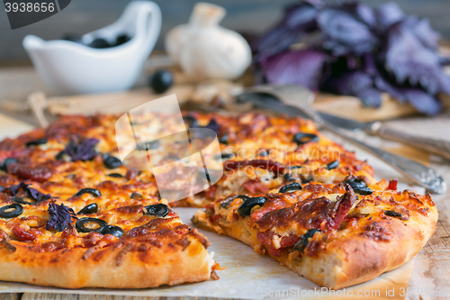 Image of Appetizing pizza with salami, black olives and cheese close up.
