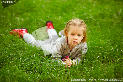 Image of Portrait of little girl lying on green grass