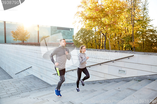 Image of happy couple running upstairs on city stairs