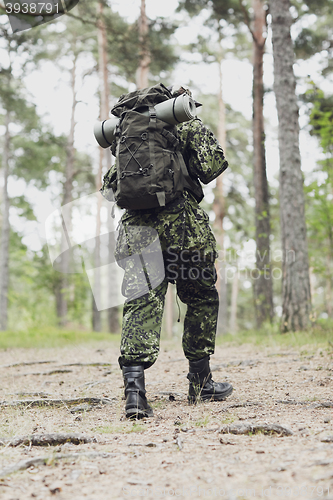 Image of young soldier with backpack in forest