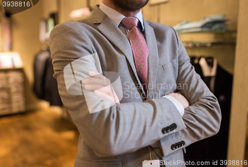 Image of close up of man in suit and tie at clothing store