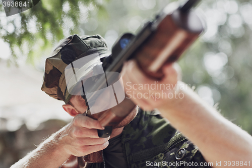 Image of soldier or hunter shooting with gun in forest