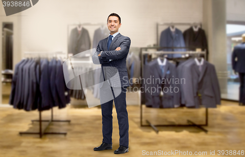 Image of happy businessman in suit over clothing store