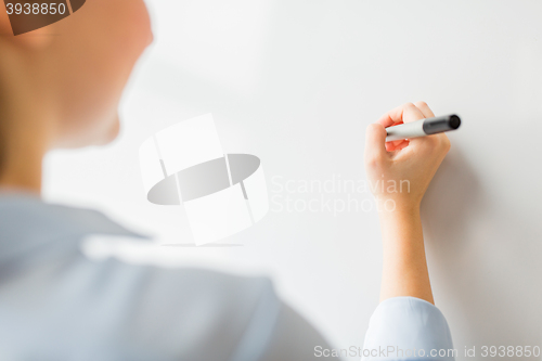 Image of close up of woman writing something on white board