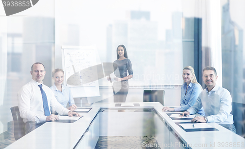 Image of group of smiling businesspeople meeting in office