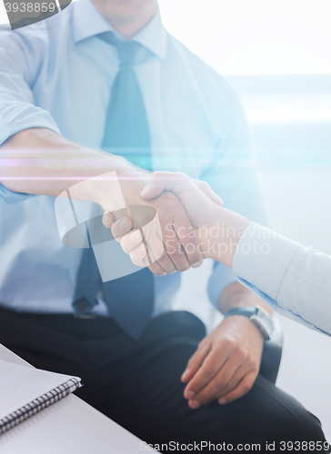 Image of businessmen shaking hands in office