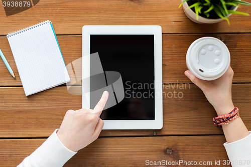 Image of close up of woman with tablet pc on wooden table