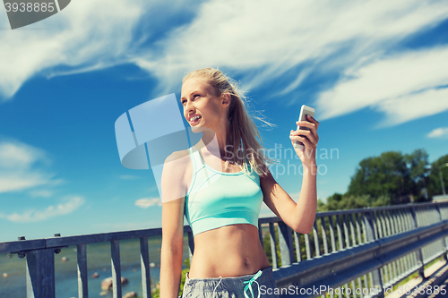 Image of happy woman with smartphone exercising outdoors