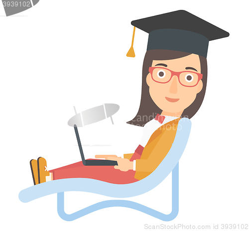 Image of Graduate lying in chaise lounge with laptop.