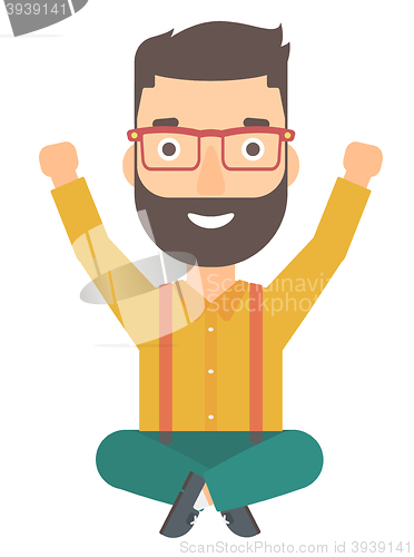 Image of Man sitting with crossed legs and raised hands up.