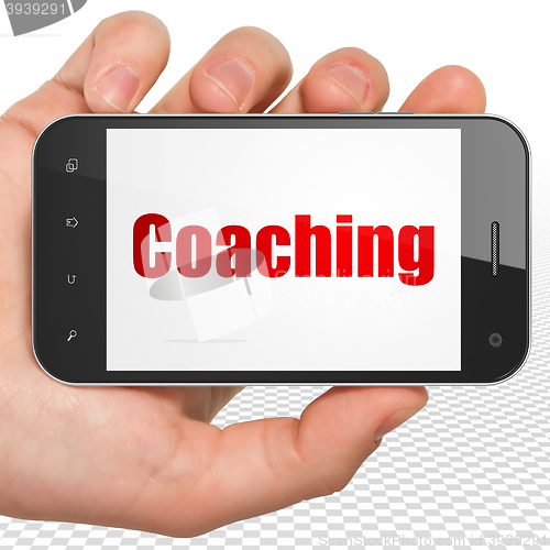 Image of Learning concept: Hand Holding Smartphone with Coaching on display