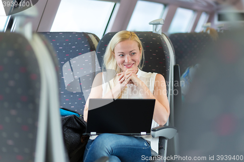 Image of Woman smiling while travelling by train.