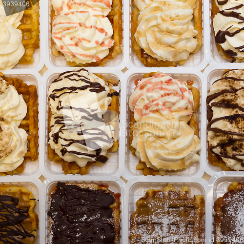 Image of Assortment of Belgium waffles with cream and toppings.