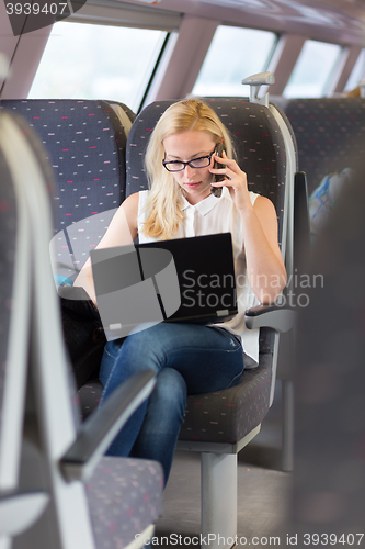 Image of Business woman working while travelling by train.