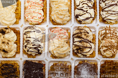 Image of Assortment of Belgium waffles with cream and toppings.