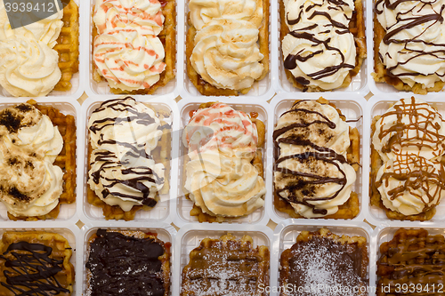 Image of Assortment of Belgium waffles with cream and toppings.