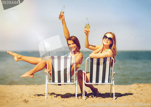 Image of girls sunbathing on the beach chairs