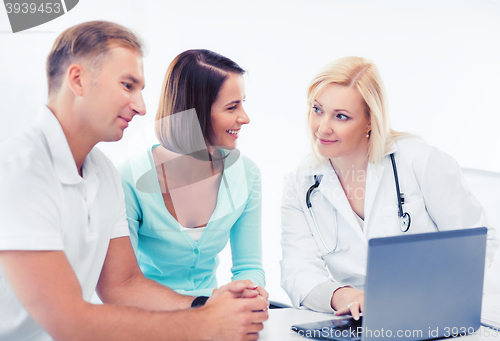 Image of doctor with patients looking at laptop