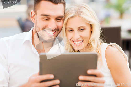 Image of happy couple with tablet pc at restaurant lounge