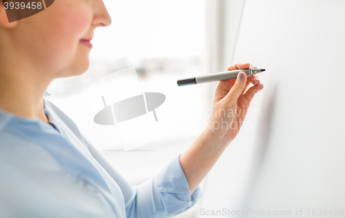 Image of close up of woman writing something on white board