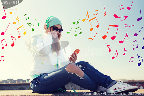 Image of happy young woman with smartphone and headphones