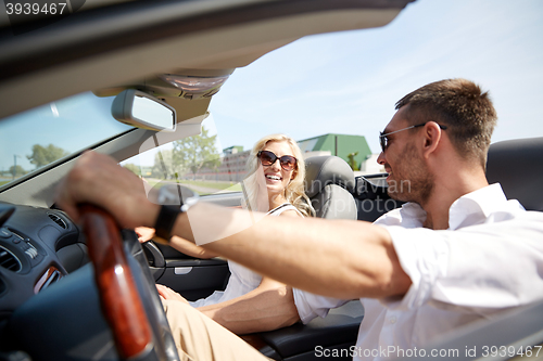 Image of happy man and woman driving in cabriolet car