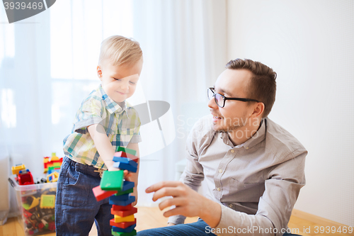 Image of father and son playing with toy blocks at home