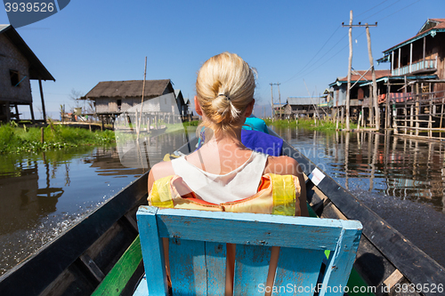 Image of Female tourist travels by traditional boat.