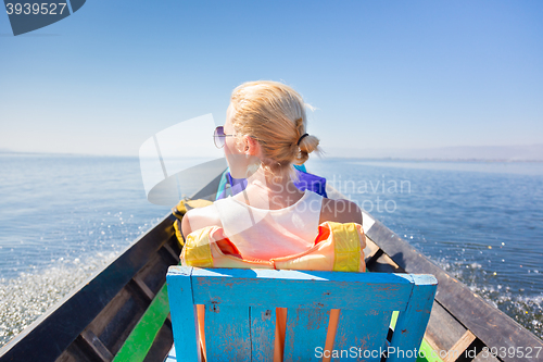 Image of Female tourist travels by traditional boat.