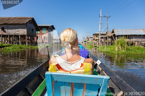 Image of Female tourist travels by traditional boat.