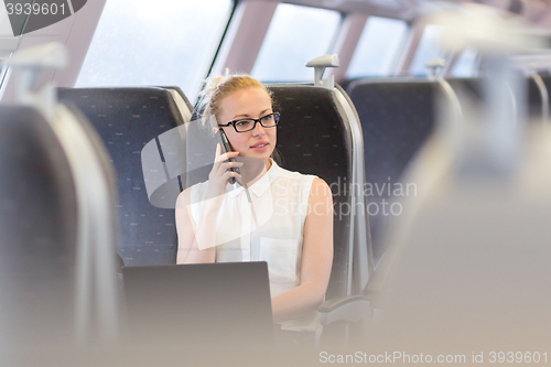 Image of Business woman working while travelling by train.