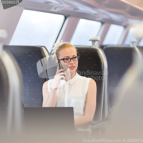 Image of Business woman working while travelling by train.