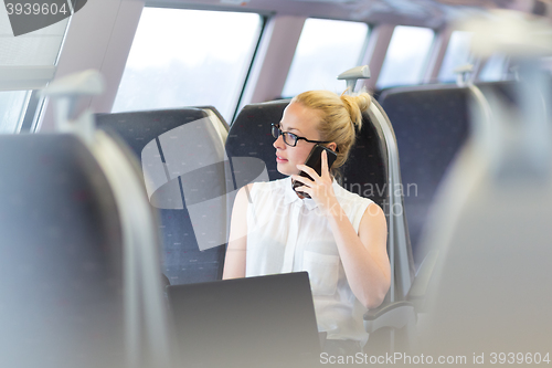 Image of Business woman working while travelling by train.