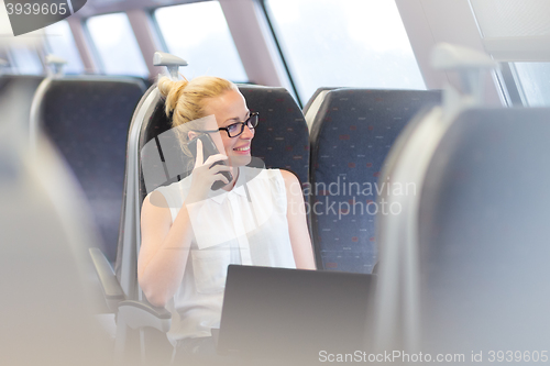 Image of Business woman working while travelling by train.