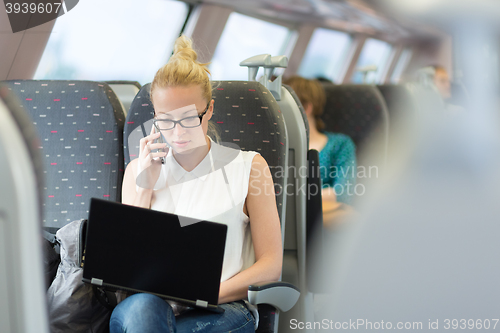 Image of Business woman working while travelling by train.